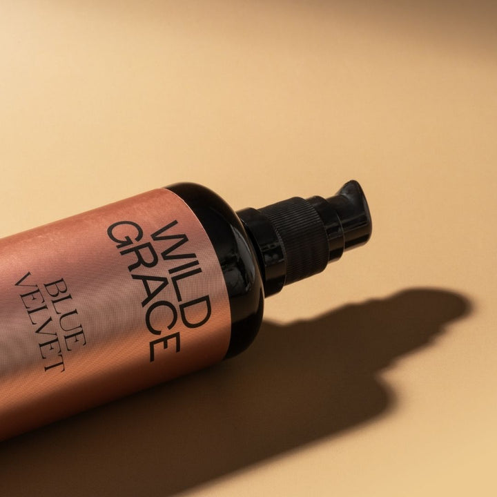 Bottle of 'Wild Grace Blue Velvet' on a beige background