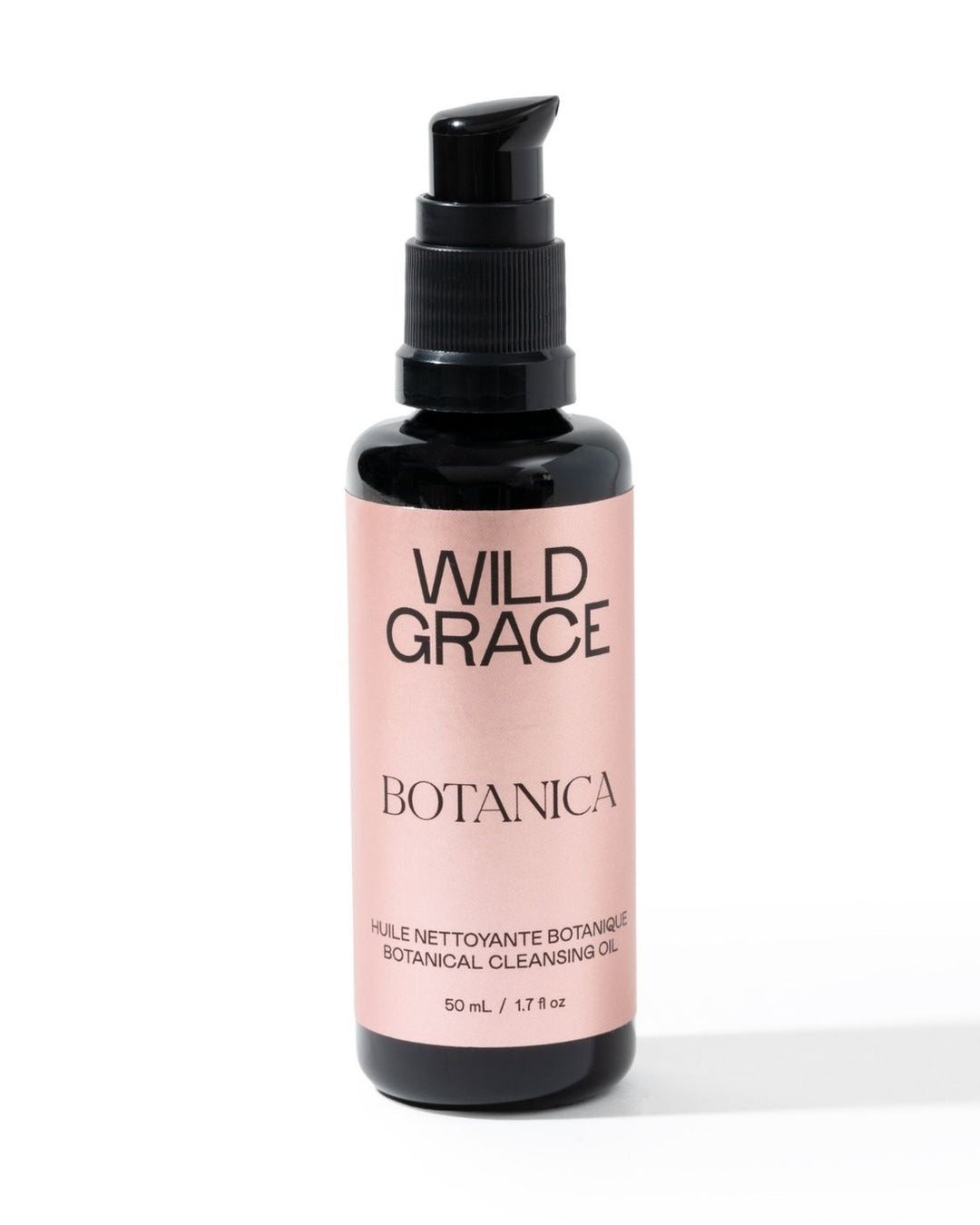 A bottle of Wild Grace Botanica Botanical Cleansing Oil on a white background. The product is in a black bottle with a black pump dispenser and a light pink label featuring black text.