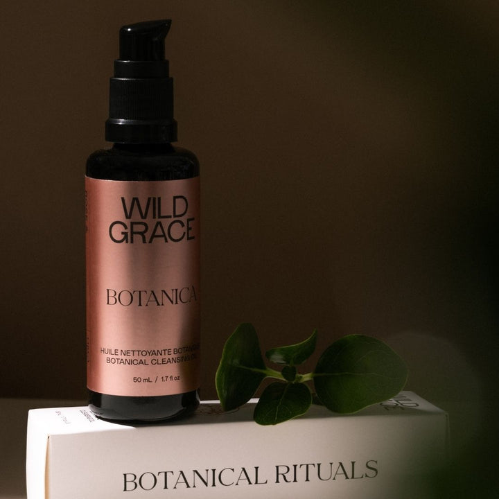 Wild Grace Botanical bottle on a box with a leaf on a brown background