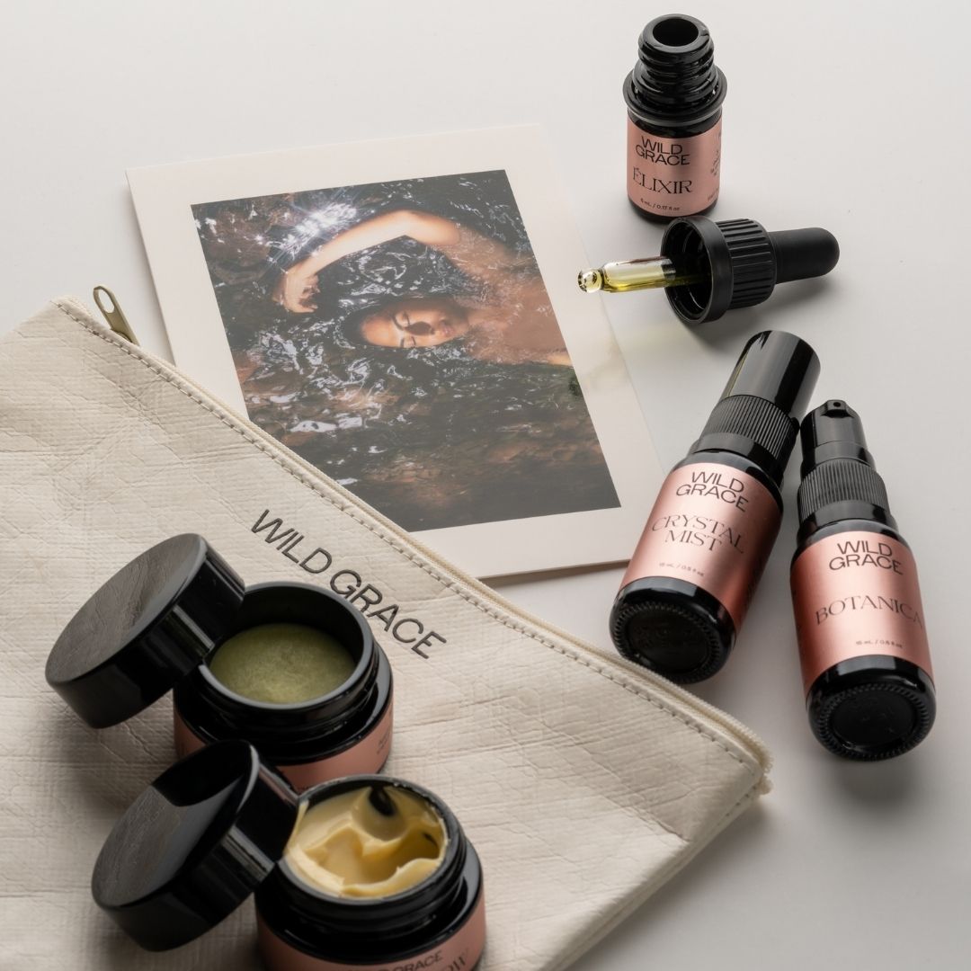Cosmetic products including jars, bottles, and a pouch with 'Wild Grace' branding on a light background.