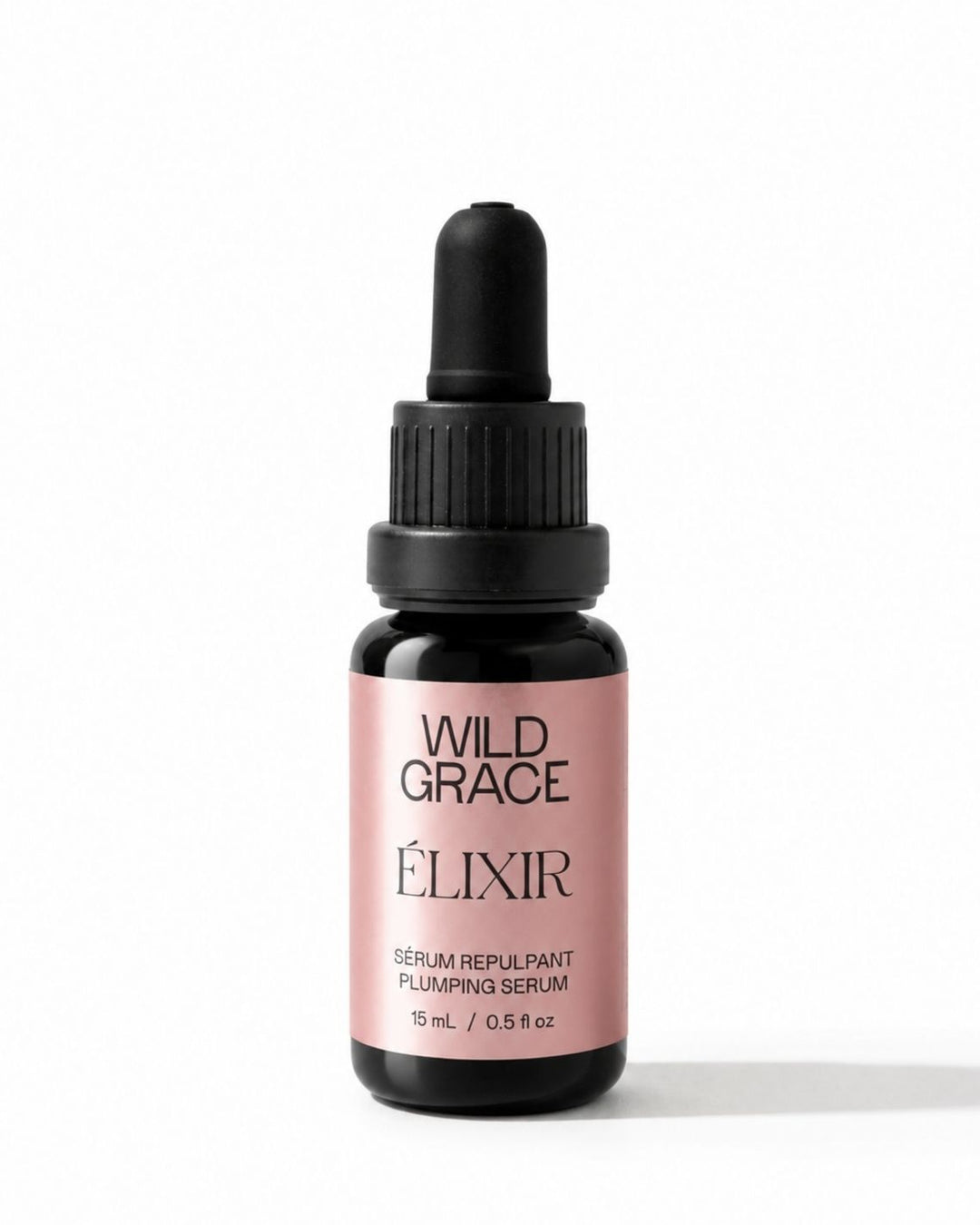 A small dropper bottle of Wild Grace Elixir Serum Repulant on a clean white background. The bottle is dark amber glass with a black dropper cap and a dusty pink label featuring black text.