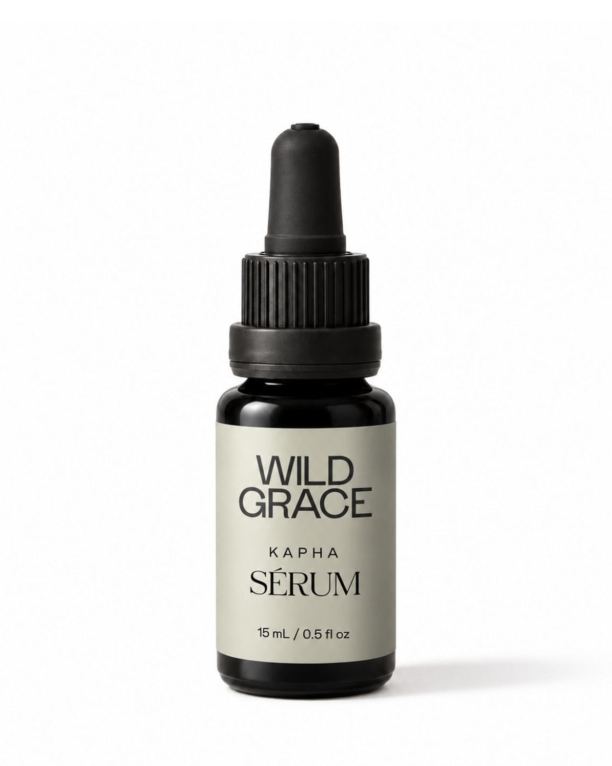 A small amber glass dropper bottle of Wild Grace Kapha Serum with a black dropper cap and a light gray label, centered on a white background.