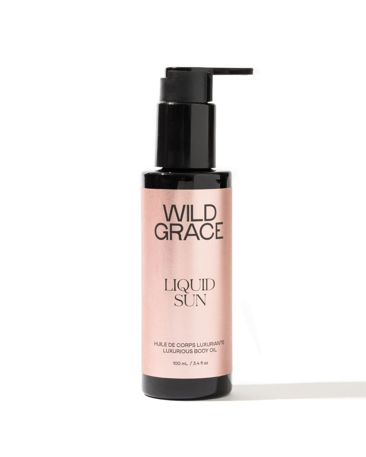 A bottle of LIQUID SUN, luxurious body oil by WILD GRACE on white background