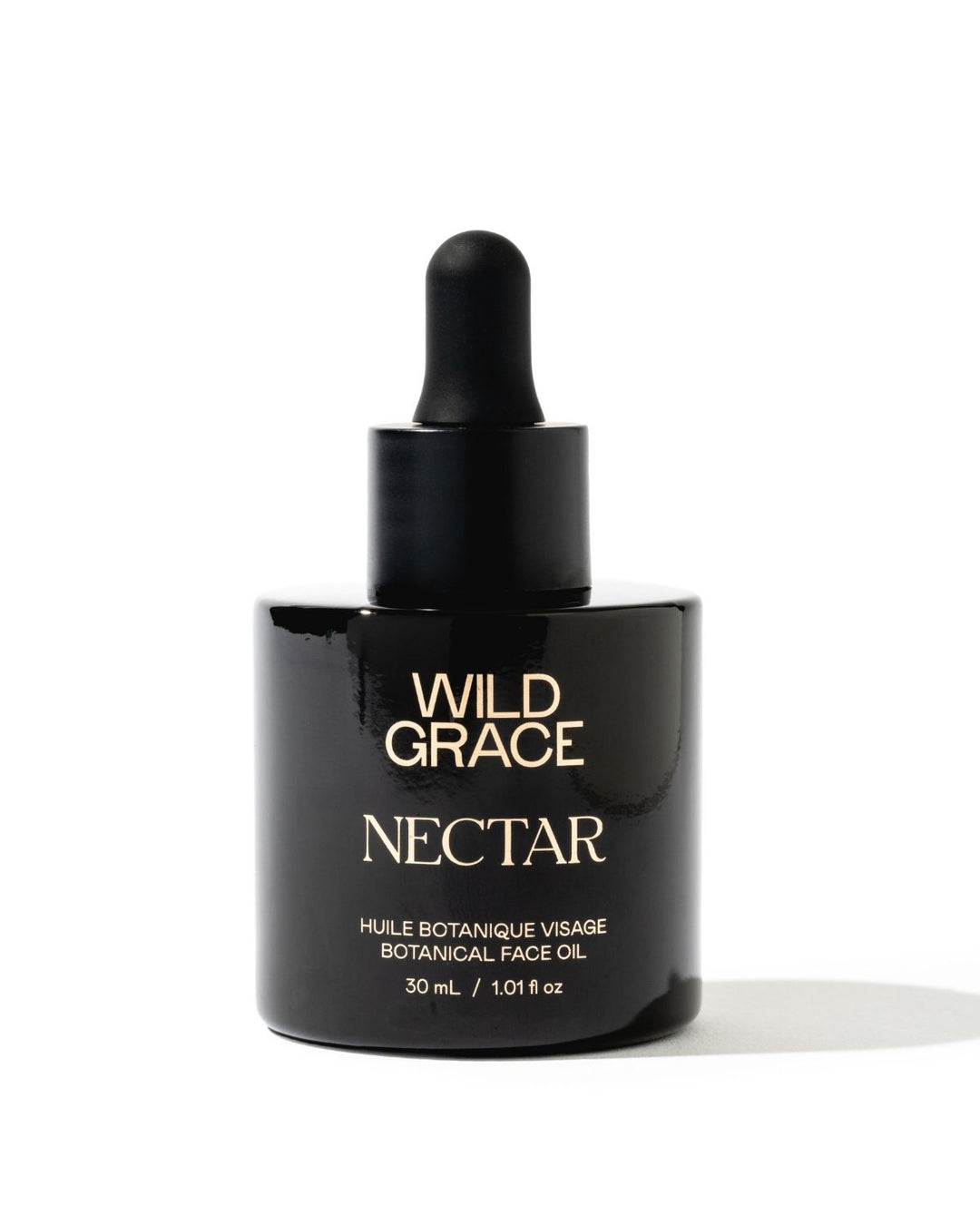 A 30 mL black glass dropper bottle of Wild Grace Nectar Botanical Face Oil with gold lettering, set against a plain white background.