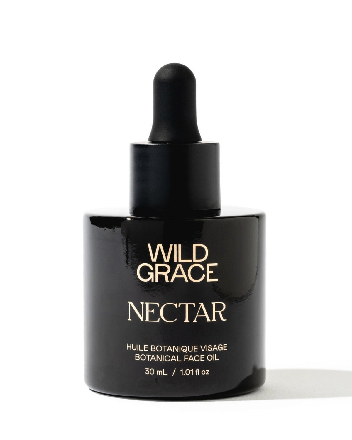 A 30 mL black glass dropper bottle of Wild Grace Nectar Botanical Face Oil with gold lettering, set against a plain white background.