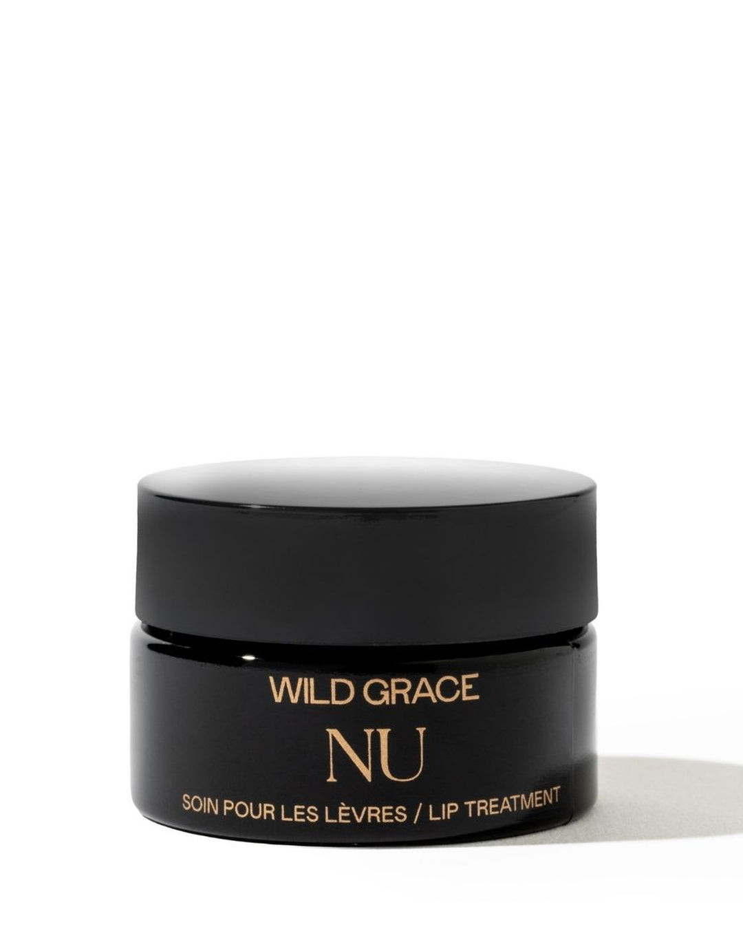 A small black cosmetic jar with a matching black lid, featuring gold text that reads &