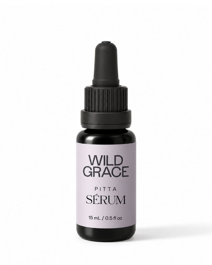A small dropper bottle of Wild Grace Pitta Sérum on a clean white background. The bottle is made of dark amber glass with a black dropper cap and features a light lavender label with black text.
