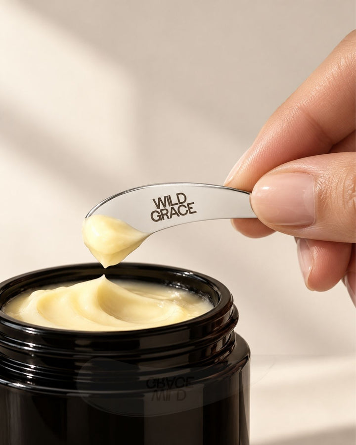 A close-up of a hand holding a silver spoon branded &