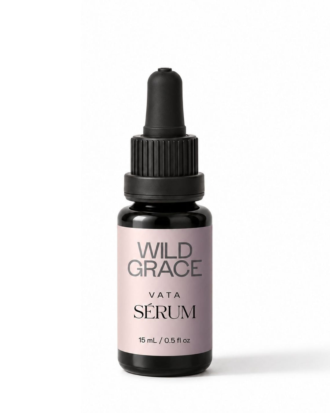A small dropper bottle of Wild Grace Vata Sérum serum on a clean white background. The bottle is made of dark amber glass with a black dropper cap and features a light dusty lavender label with black text.