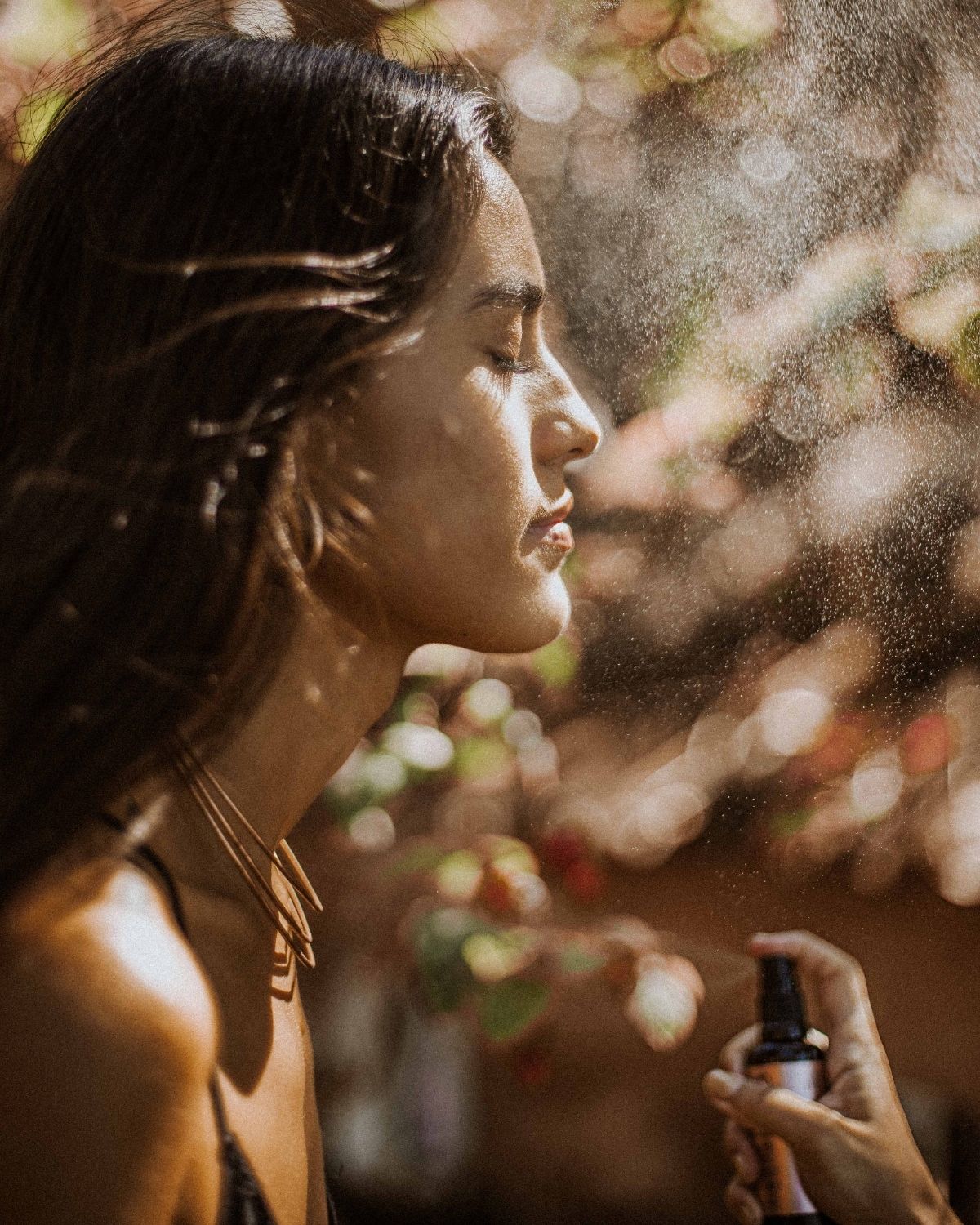Woman misting her face with wild grace crystal mist toner on a blurred background