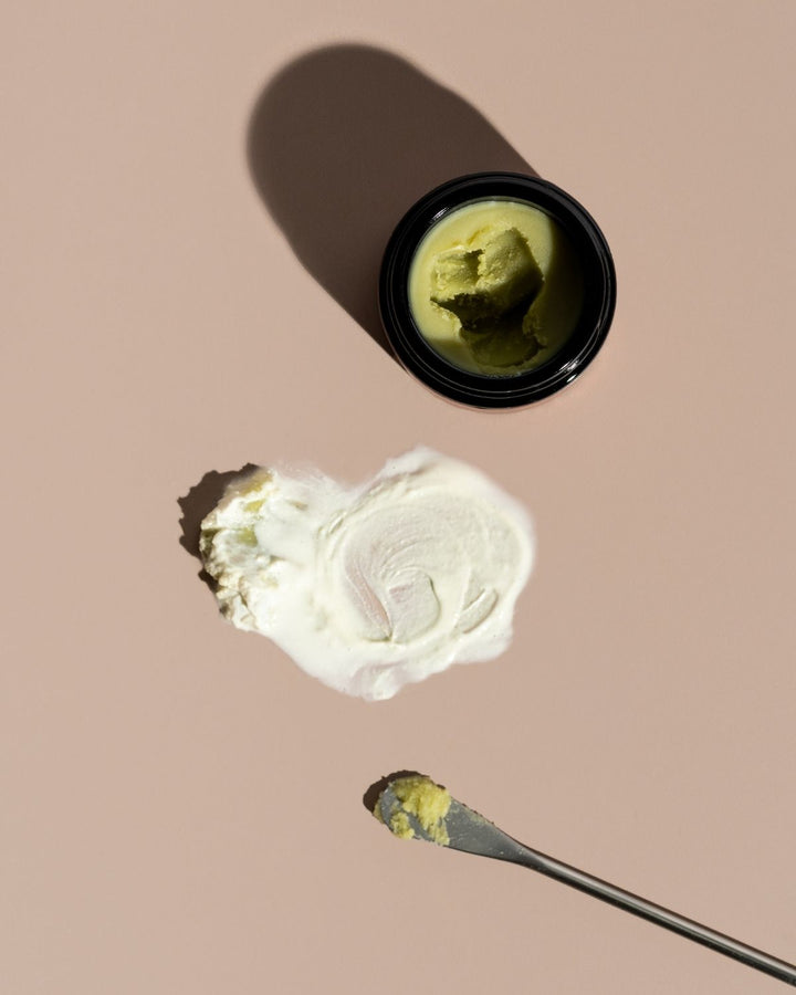 Jay of deep forest cleansing balm, mixed with water, on a beige background with a spoon.