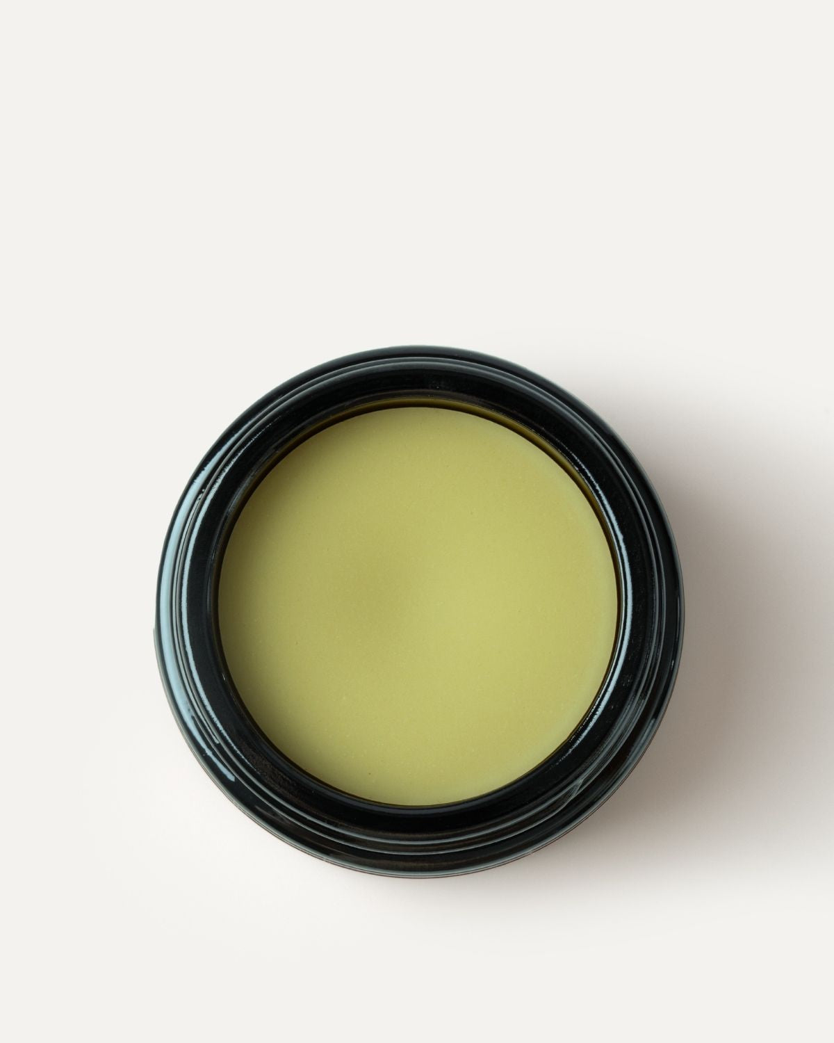 Jar of green deep forest cleansing balm on a white background