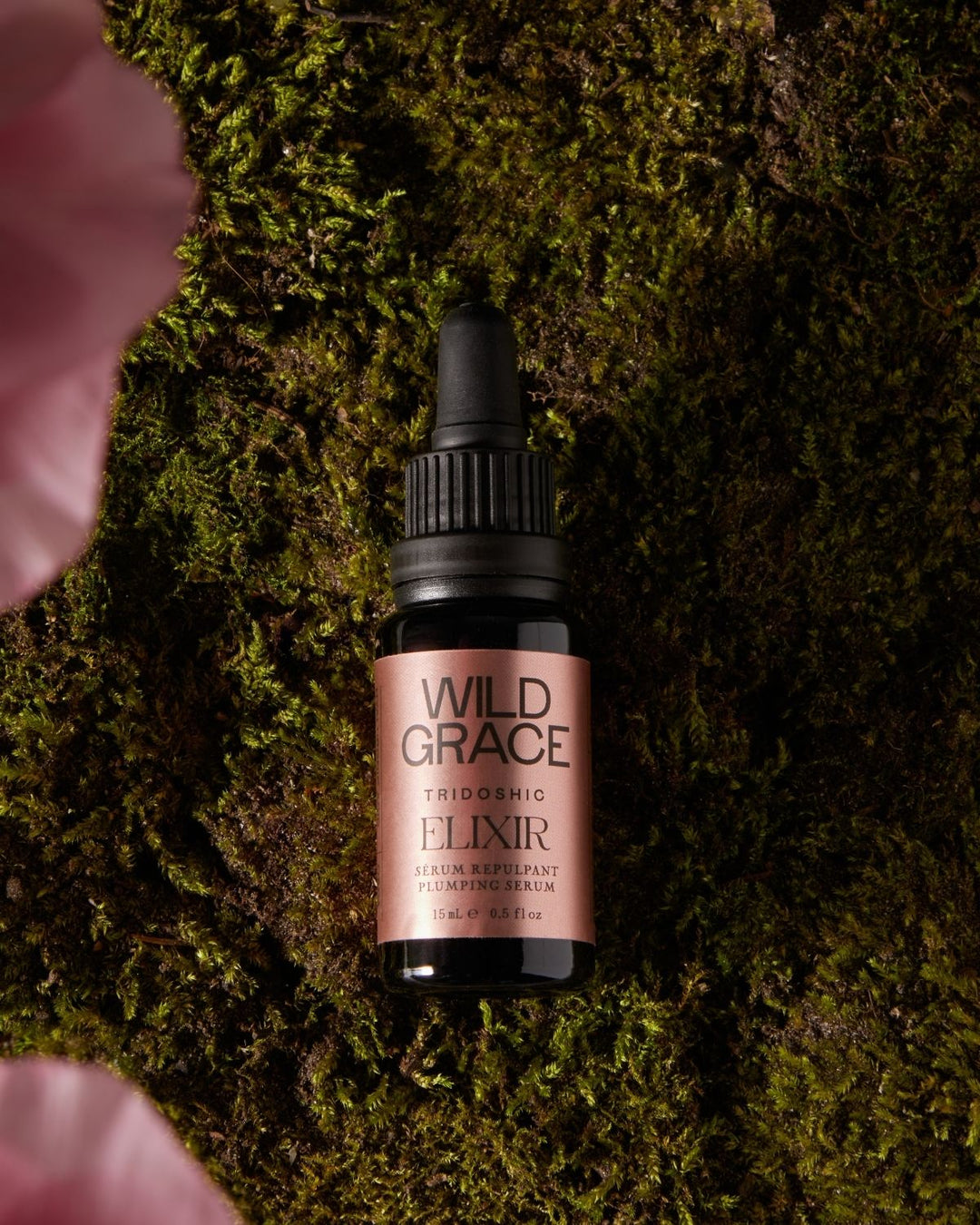 Bottle of Wild Grace Elixir on a mossy background