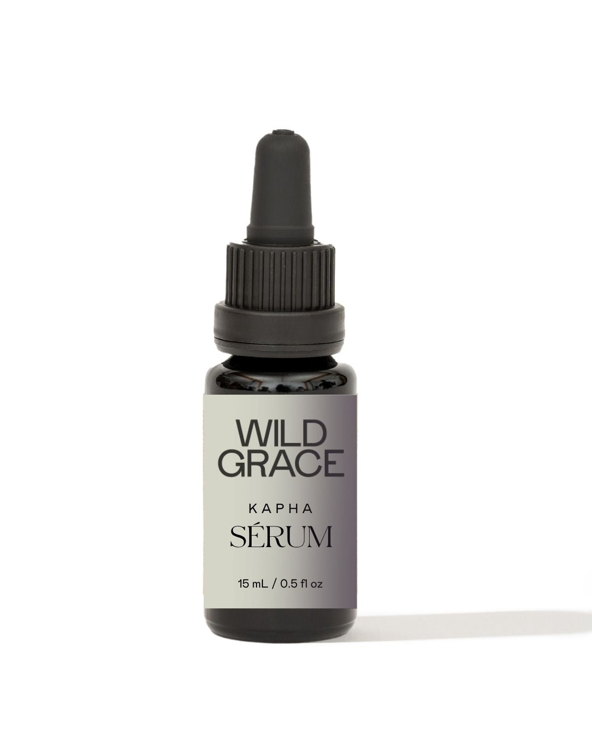 A small dark glass dropper bottle with a black cap and a white label reading 'WILD GRACE KAPHA SÉRUM' on a clean white background.