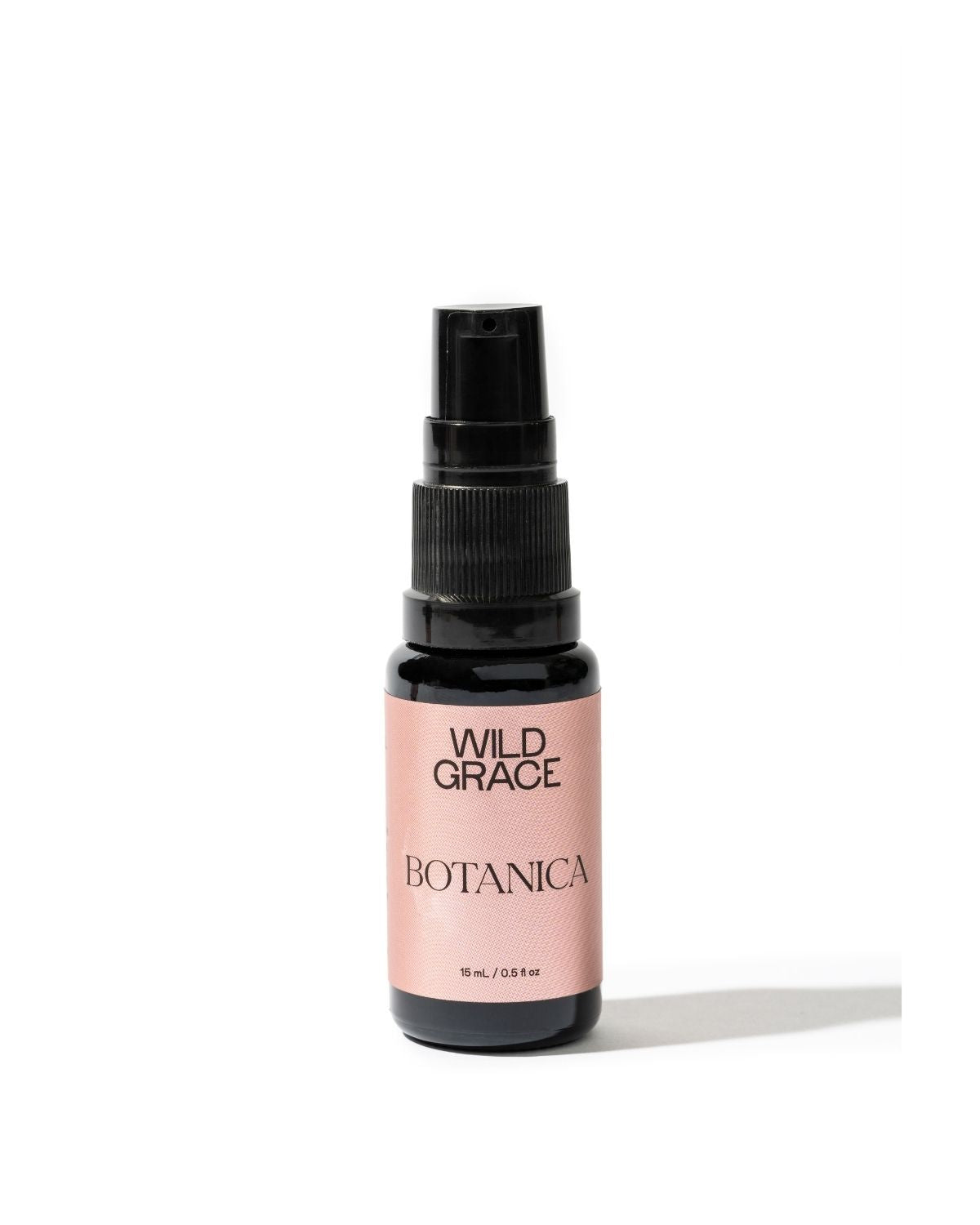 A small Wild Grace Botanica spray bottle with a black pump and a dusty pink label, set against a plain white background.