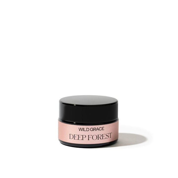 Cosmetic jar labeled 'Wild Grace Deep Forest' on a white background