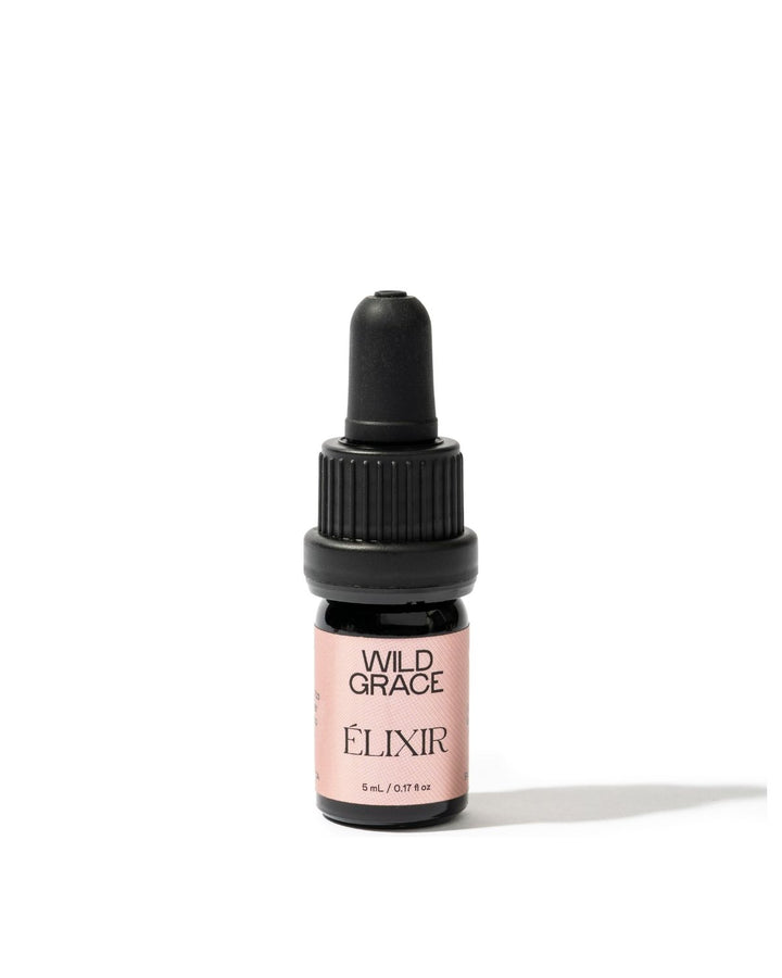 A small amber glass dropper bottle with a black cap and a dusty pink label reading &