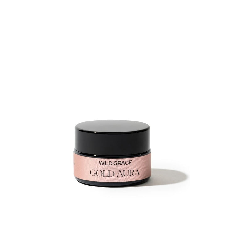 Cosmetic jar labeled 'Gold Aura' by 'Wild Grace' on a white background