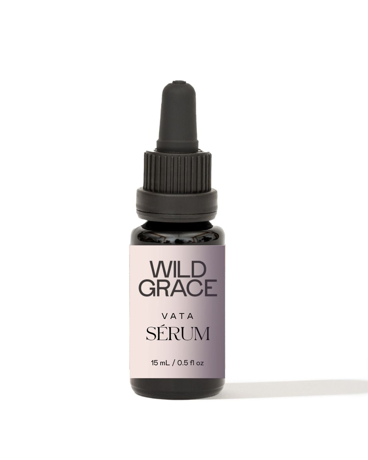 A small amber glass dropper bottle with a black cap and a lavender label reading 'WILD GRACE VATA SÉRUM' on a clean white background.